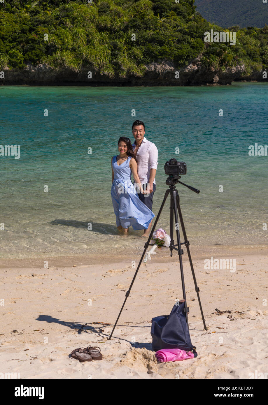 Coppia giapponese in posa nella laguna tropicale con chiare acque blu nella baia di kabira, isole yaeyama, ishigaki, Giappone Foto Stock