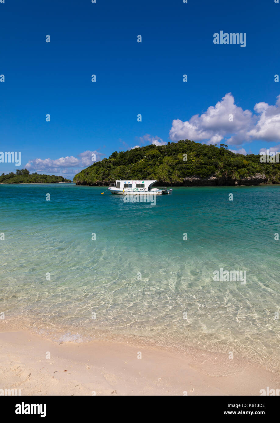 In barca dal fondo di vetro nella laguna tropicale spiaggia con acque cristalline e la sabbia bianca circondata da una vegetazione lussureggiante di kabira bay, isole yaeyama, ishigaki, Giappone Foto Stock