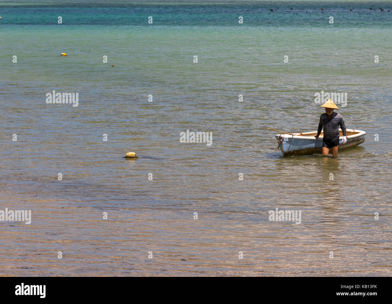 Pescatore giapponese nella laguna tropicale con chiare acque blu nella baia di kabira, isole yaeyama, ishigaki, Giappone Foto Stock