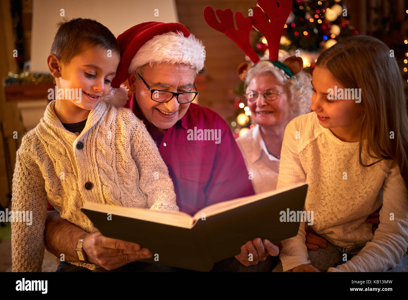 Momenti di famiglia appartenenza-lettura sulla xmas Libro magico Foto Stock