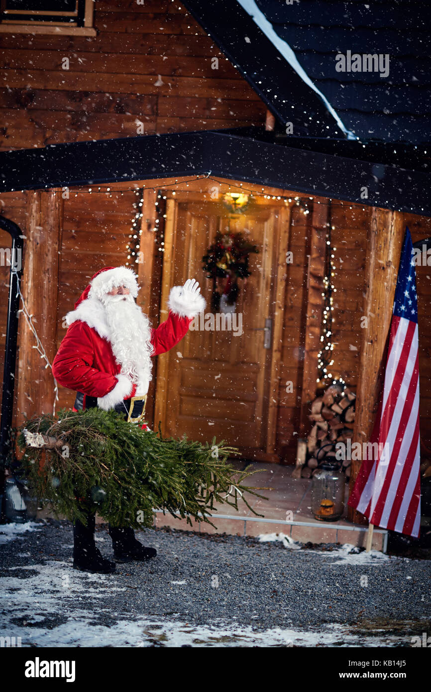Natale, vacanze e concetto di persone - Babbo Natale con albero di natale sventolando Foto Stock