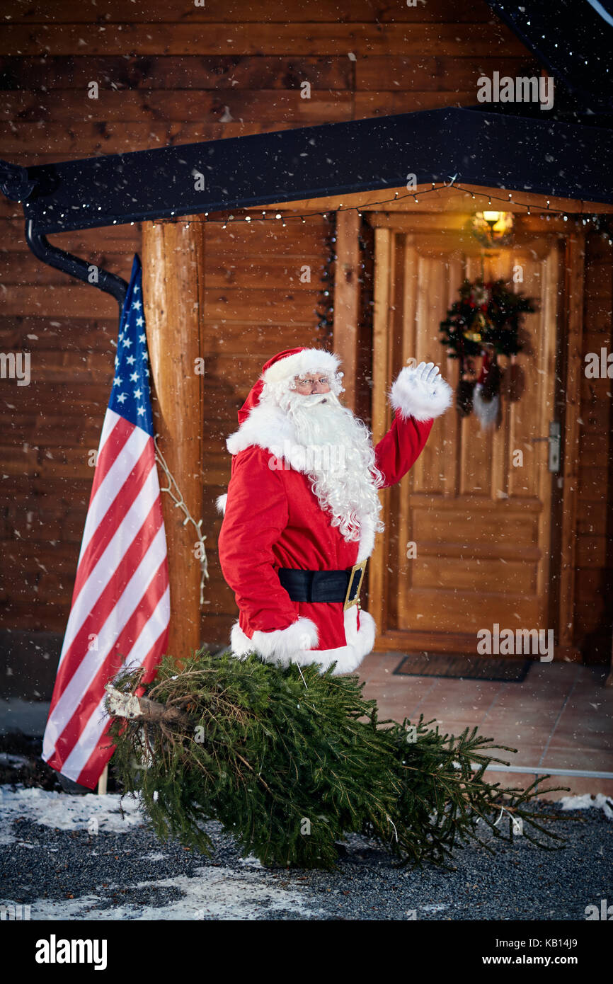 Babbo Natale con albero di natale sventolando-natale, vacanze e concetto di persone Foto Stock