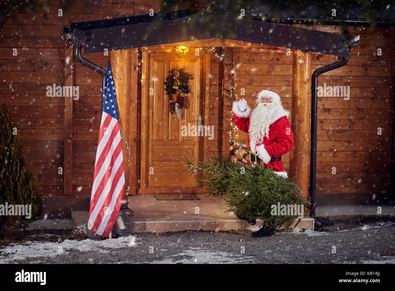 Real santa claus davanti la sua casa in legno in nevicata con albero di natale Foto Stock