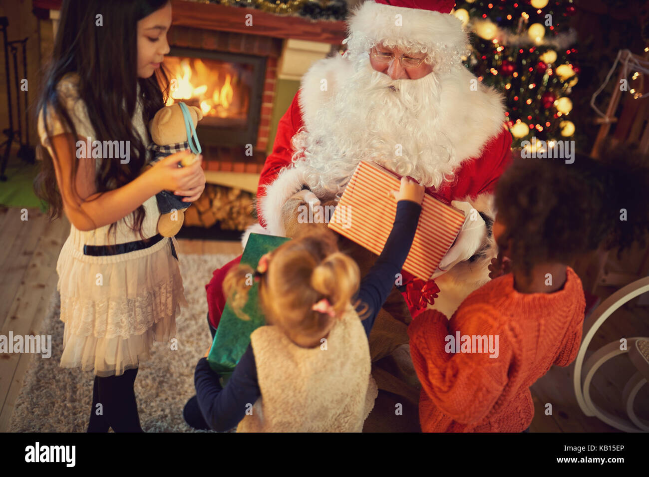 Un gruppo di ragazze multietnica ricevere regali di Natale con Babbo Natale Foto Stock
