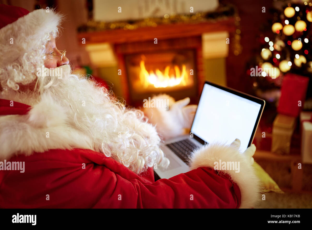 Santa Claus atmosfera calda in soggiorno utilizzando laptop Foto Stock