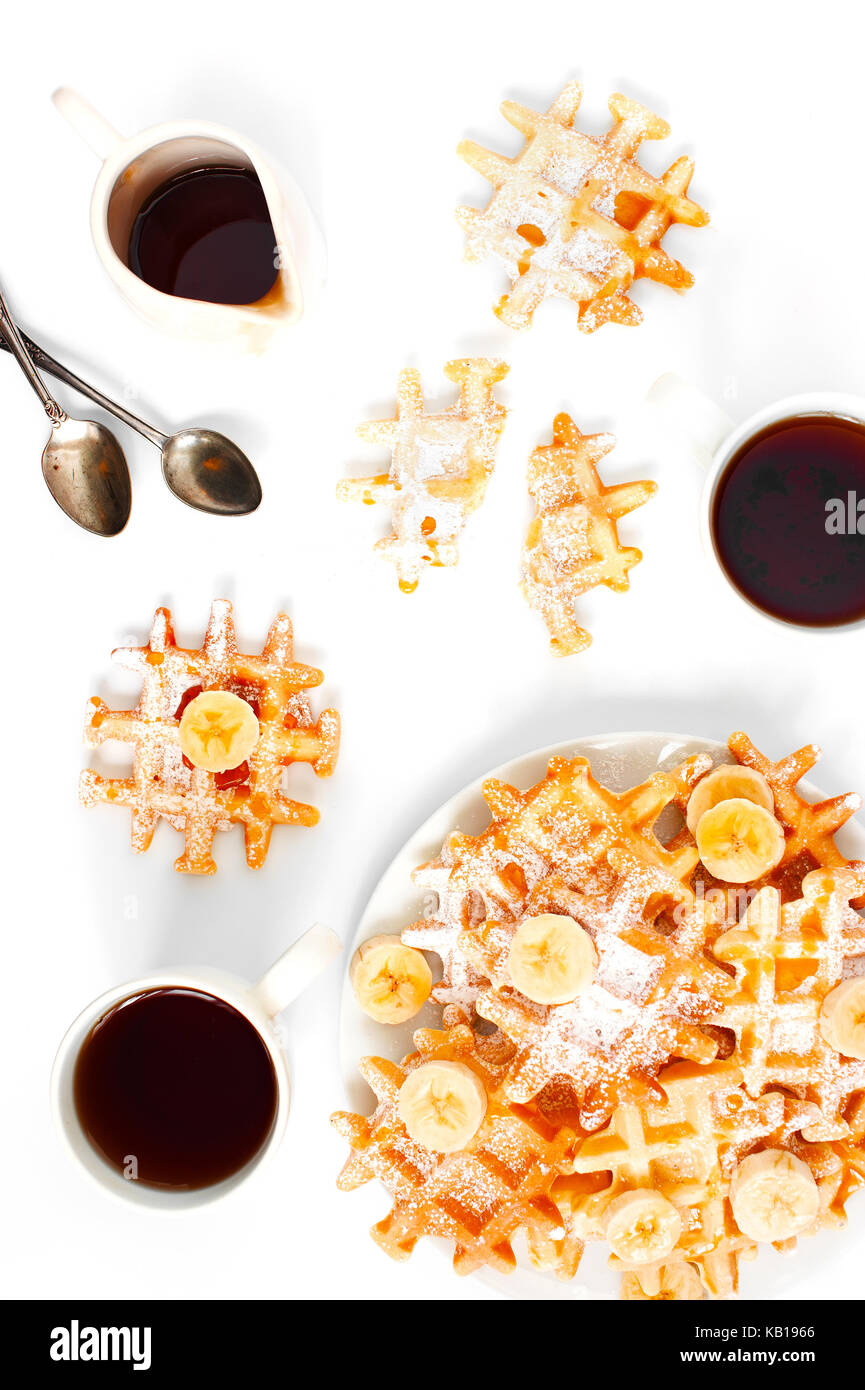 Waffles Freschi Fatti in casa e due tazze di tè sul tavolo bianco Foto Stock