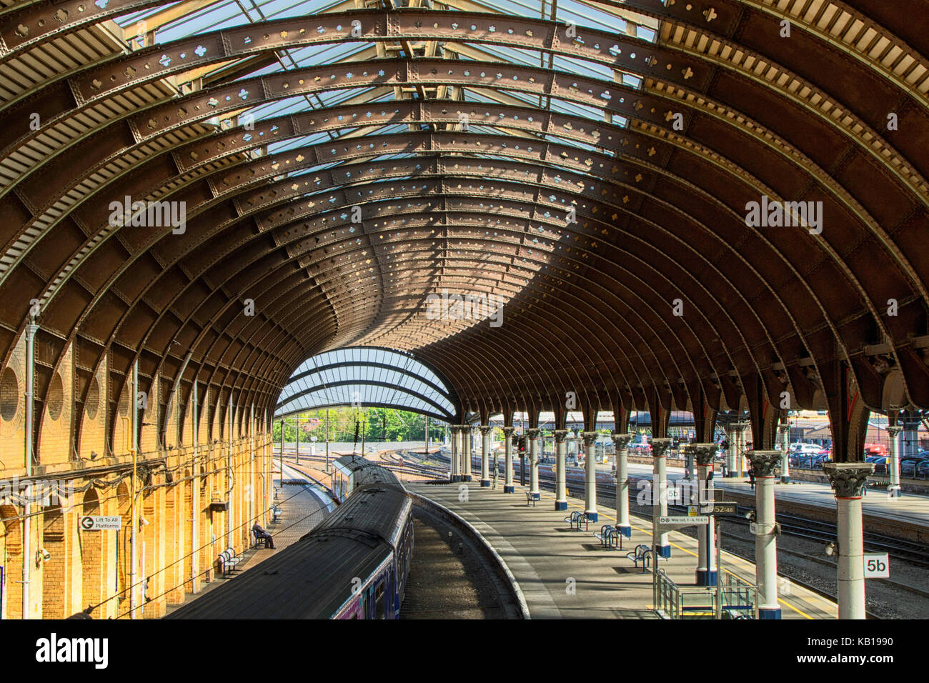 Treno diesel sulla linea di Harrogate alla stazione ferroviaria di York con un tetto curvo in acciaio. York, North Yorkshire, Inghilterra, Regno Unito Foto Stock