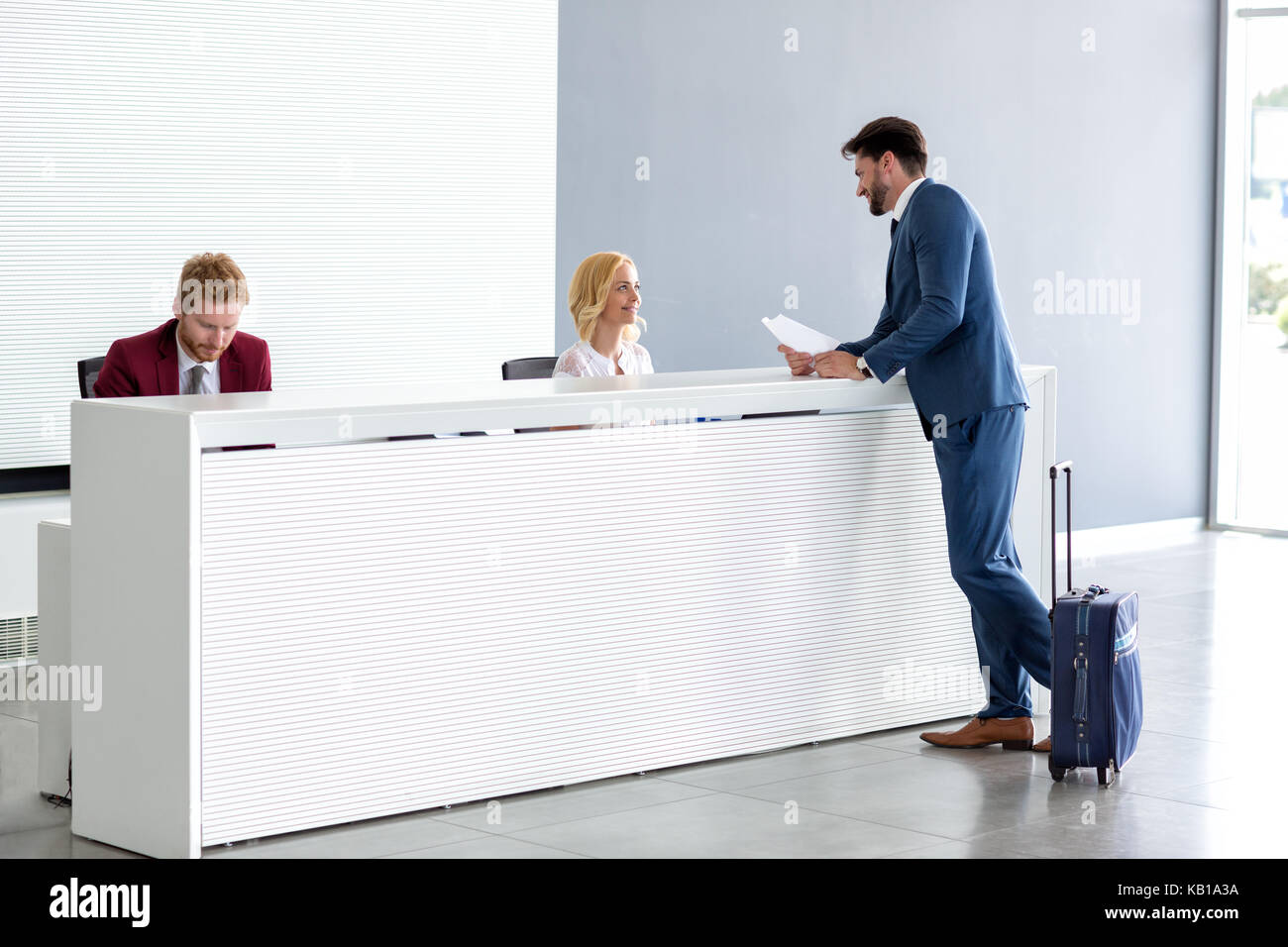 Giovane imprenditore bello flirtare con la receptionist femmina Foto Stock