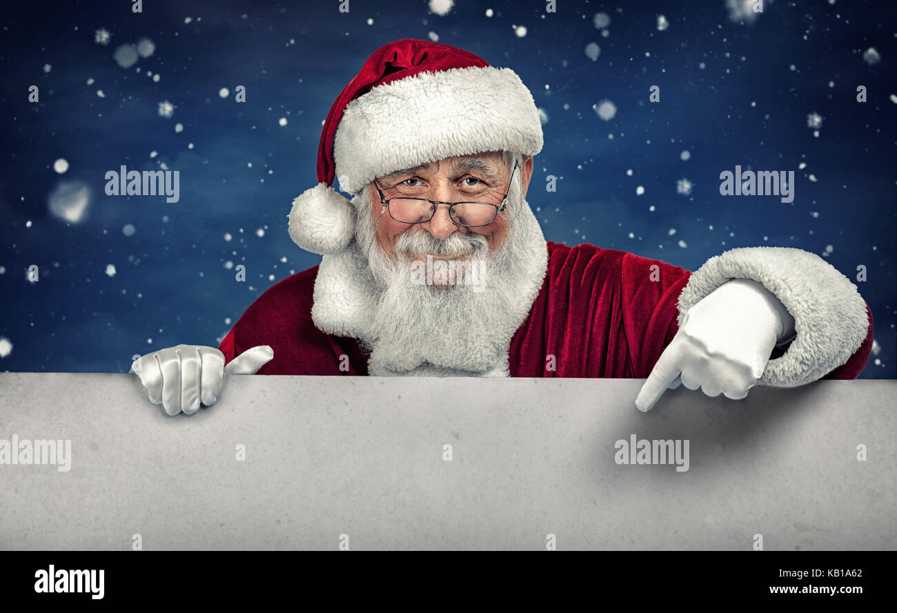 Babbo Natale rivolti in bianco segno vuoto con sorriso, in inverno la neve sullo sfondo Foto Stock