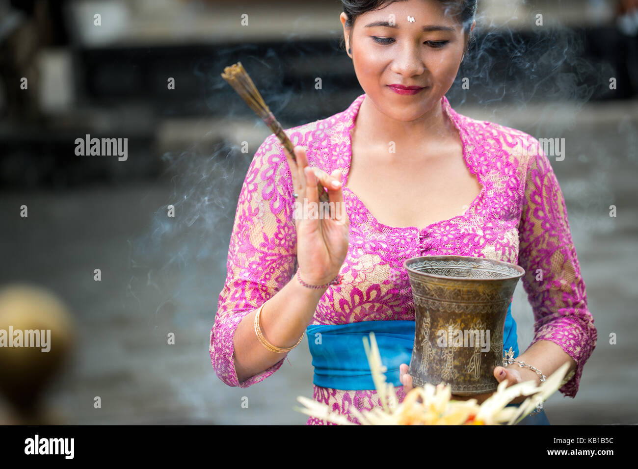 Cerimonia di pregare in un tempio indù, donna balinese in abiti cerimoniali pregando Foto Stock