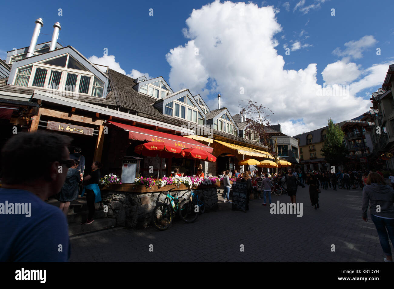 Fiori d'estate e ristoranti rendono la scena colorati in Whistler Village, Whistler, BC, Canada. Foto Stock