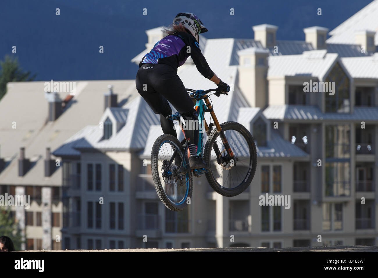 Una femmina di mountain biker catture aria sulla linea di un trail a Whistler Resort. Whistler, British Columbia, 13 agosto 2017. Foto Stock
