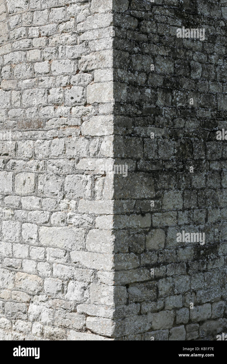Angolo vecchio muro di pietra con verticali linea d'ombra Foto Stock
