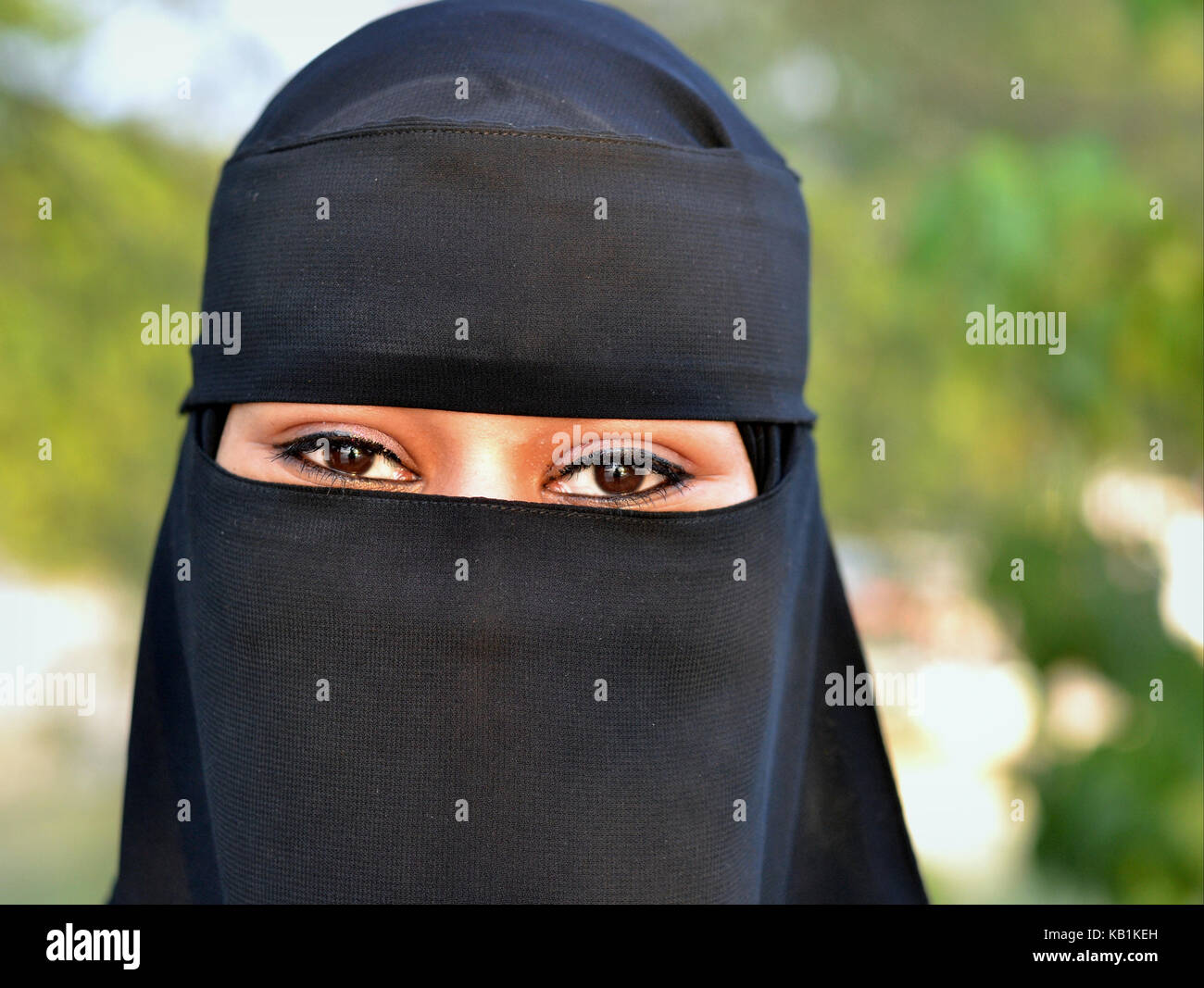 Honeymooning giovani sudanesi donna vestita di nero e niqab burqa nero con solo una piccola apertura per il suo bellissimo, occhi a mandorla Foto Stock
