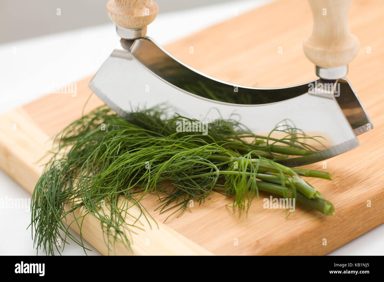 Più aneto fresco e culla coltello su una tavola di legno, Foto Stock