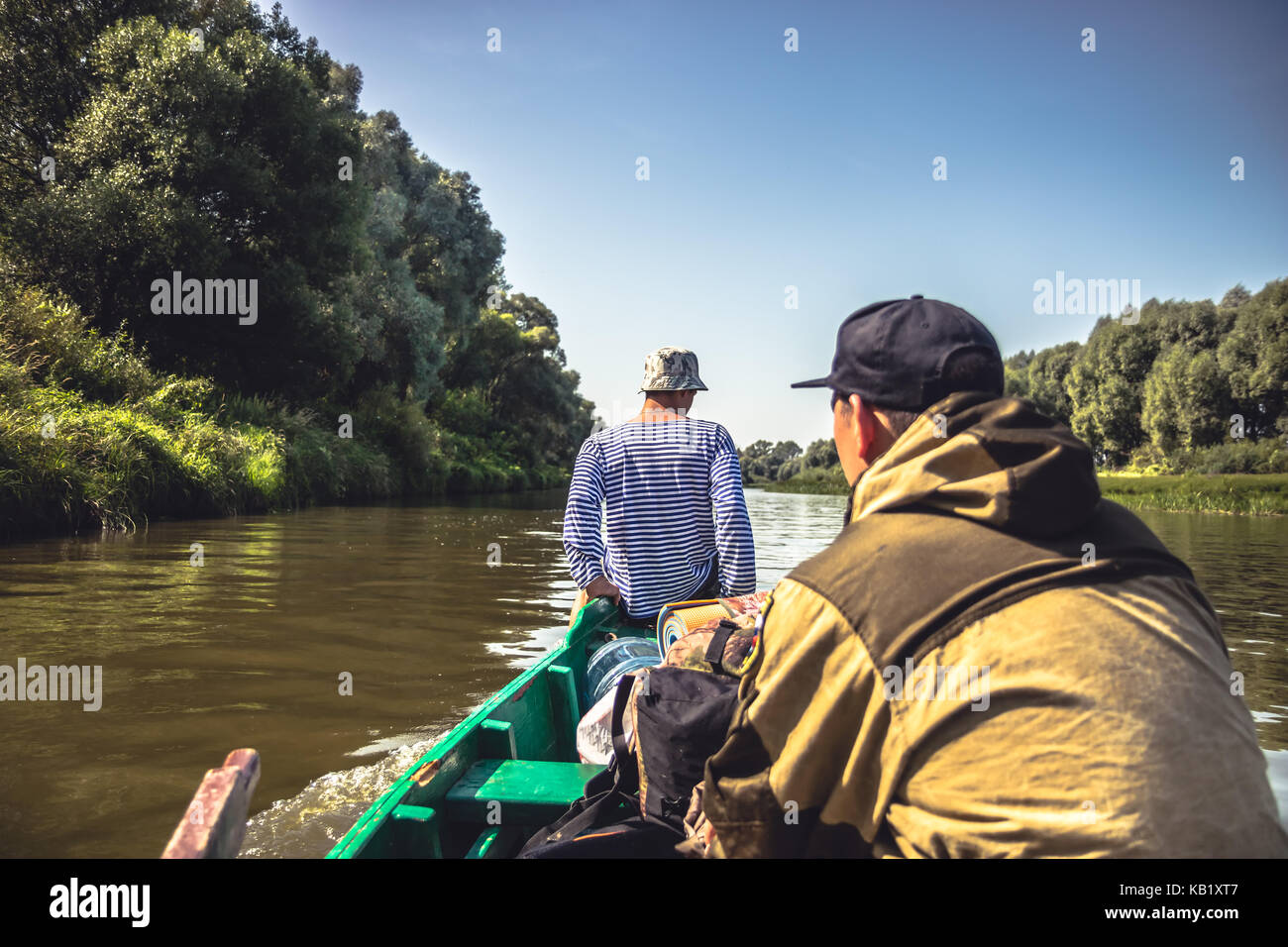 Gli uomini della vela sul motore barca da fiume per la caccia camp durante la stagione di caccia Foto Stock