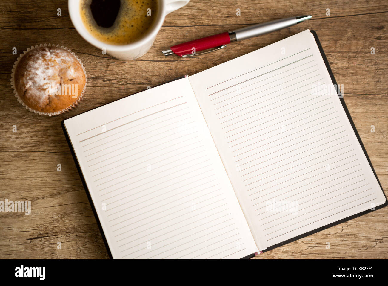 Aprire il notebook vuota e la tazza di caffè sul vecchio tavolo in legno Foto Stock