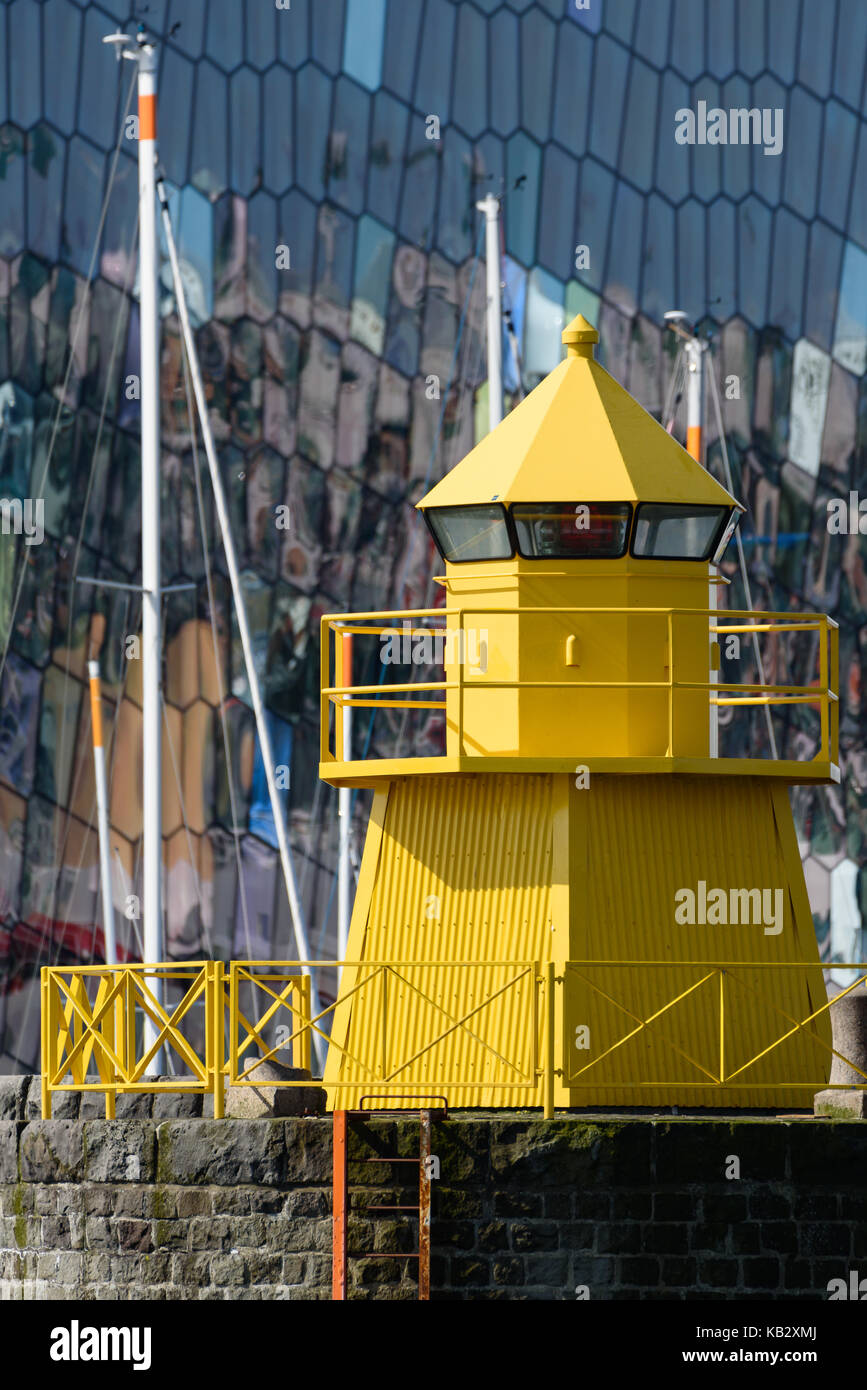 Faro giallo in Reykjavik, Islanda harbour con colorate e abstract esterno di vetro del concerto di harpa sullo sfondo con riflessioni che mi Foto Stock