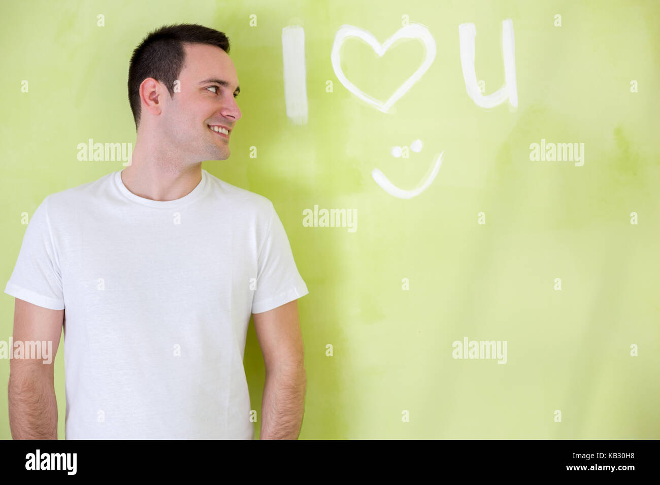 Amare l uomo appoggiato contro una parete con le parole: "ti amo" Foto Stock