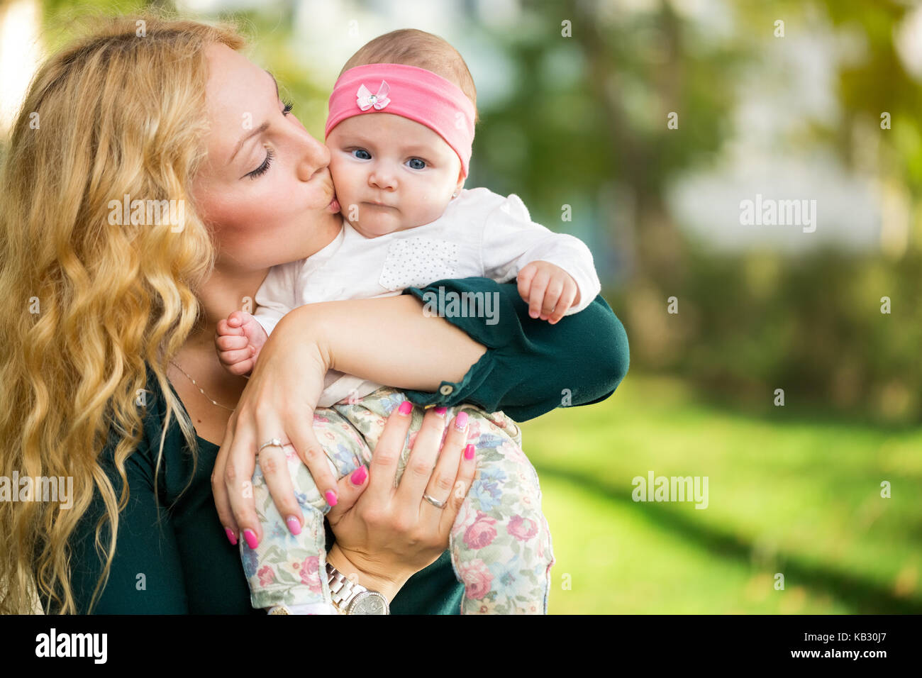 Madre kiss baby in mani, concetto - amore genitore Foto Stock