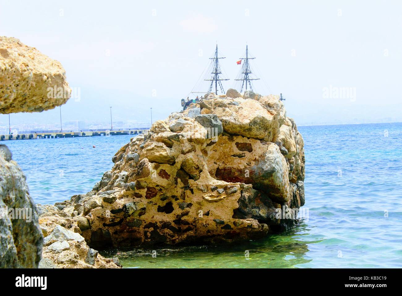 Un enorme masso nasconde dagli occhi di una nave a vela sulla spiaggia vicino alla torre rossa (Alanya, Turchia). Foto Stock