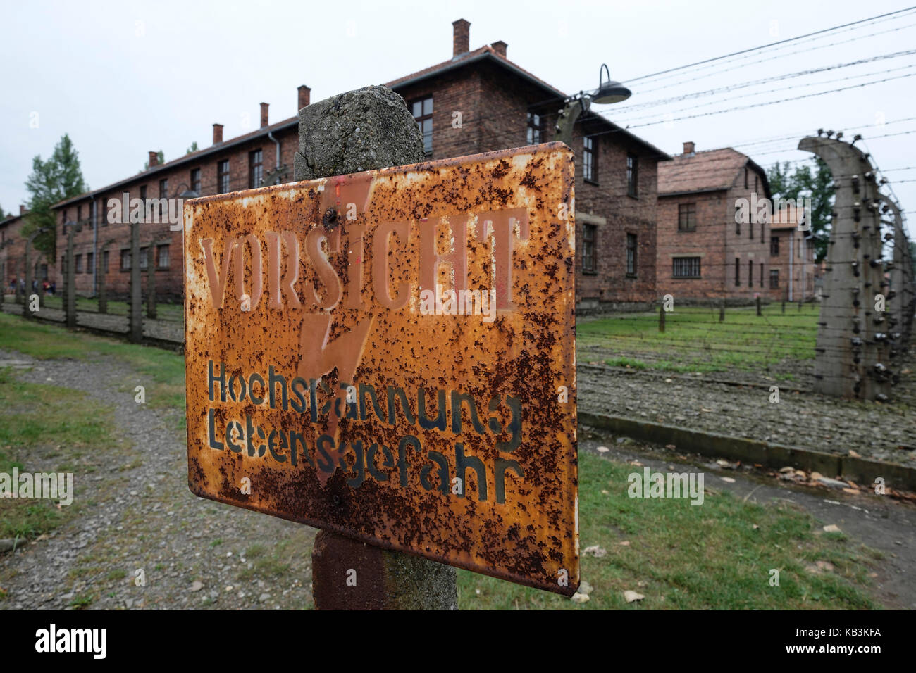 Segnale di avvertimento per indicare le recinzioni elettriche a Auschwitz WWII campo di concentramento nazista, Polonia Foto Stock