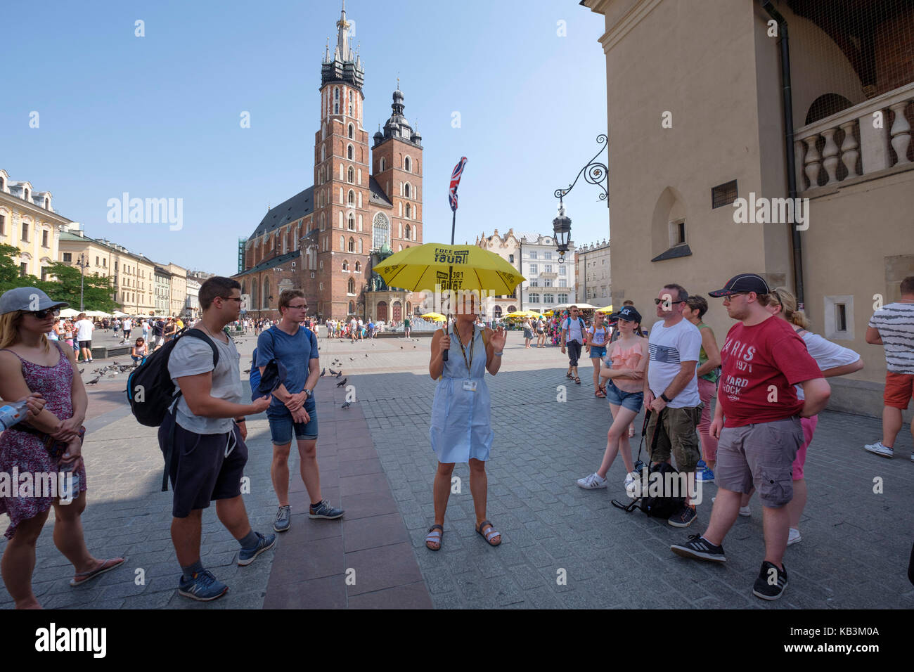 I turisti in ascolto per tour guida nella Piazza Principale di Cracovia, in Polonia, in Europa Foto Stock