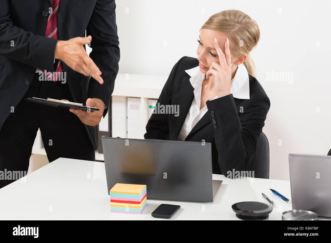 Close-up di commercianti a parlare con il dipendente ha sottolineato per il suo errore nel lavoro Foto Stock