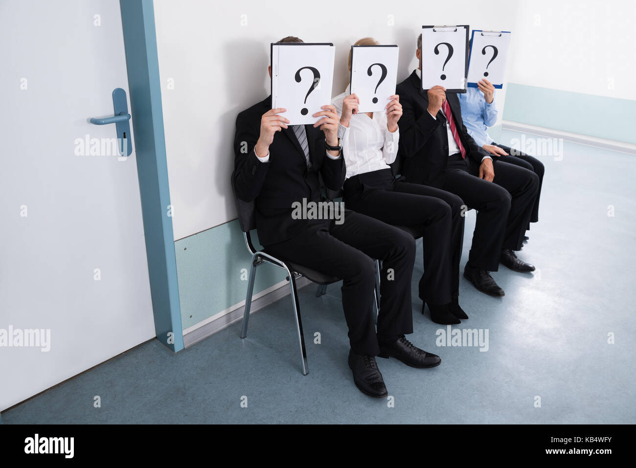 Gli imprenditori seduti su una sedia di nascondersi dietro il punto interrogativo segno Foto Stock