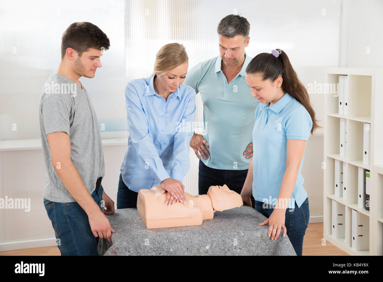 Gruppo di studenti imparare la rianimazione cardiopolmonare in classe Foto Stock