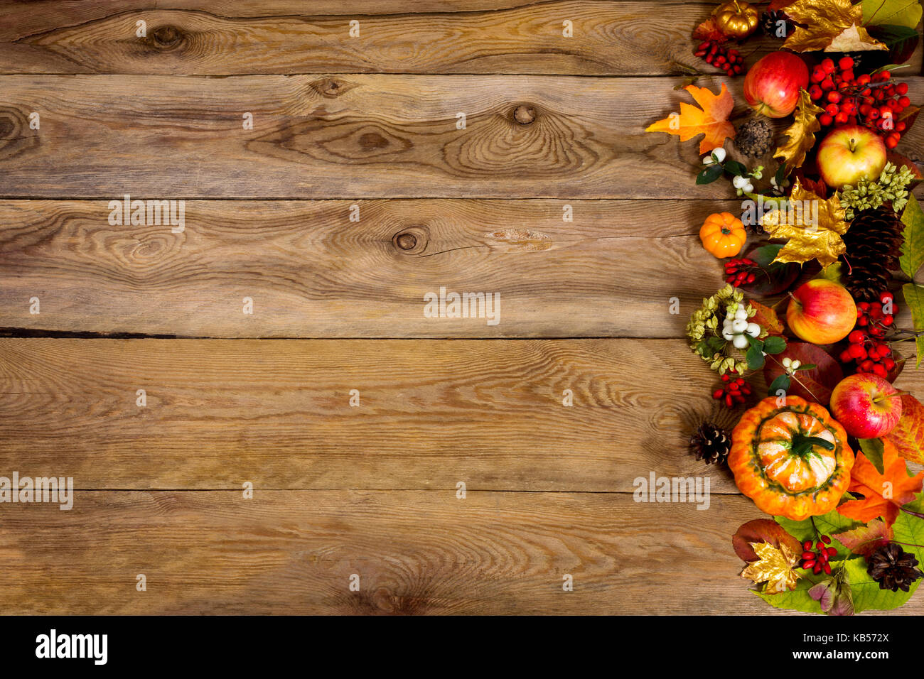 Autunno sfondo con telaio di zucche, mele e foglie d'oro sul lato sinistro della tavola in legno rustico. ringraziamento saluto con simboli di autunno, c Foto Stock