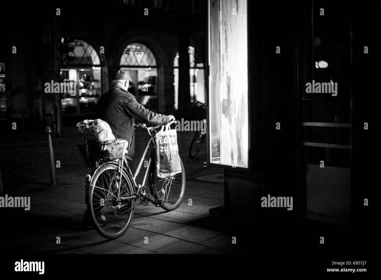 Uomo vecchio con la bicicletta in città Foto Stock