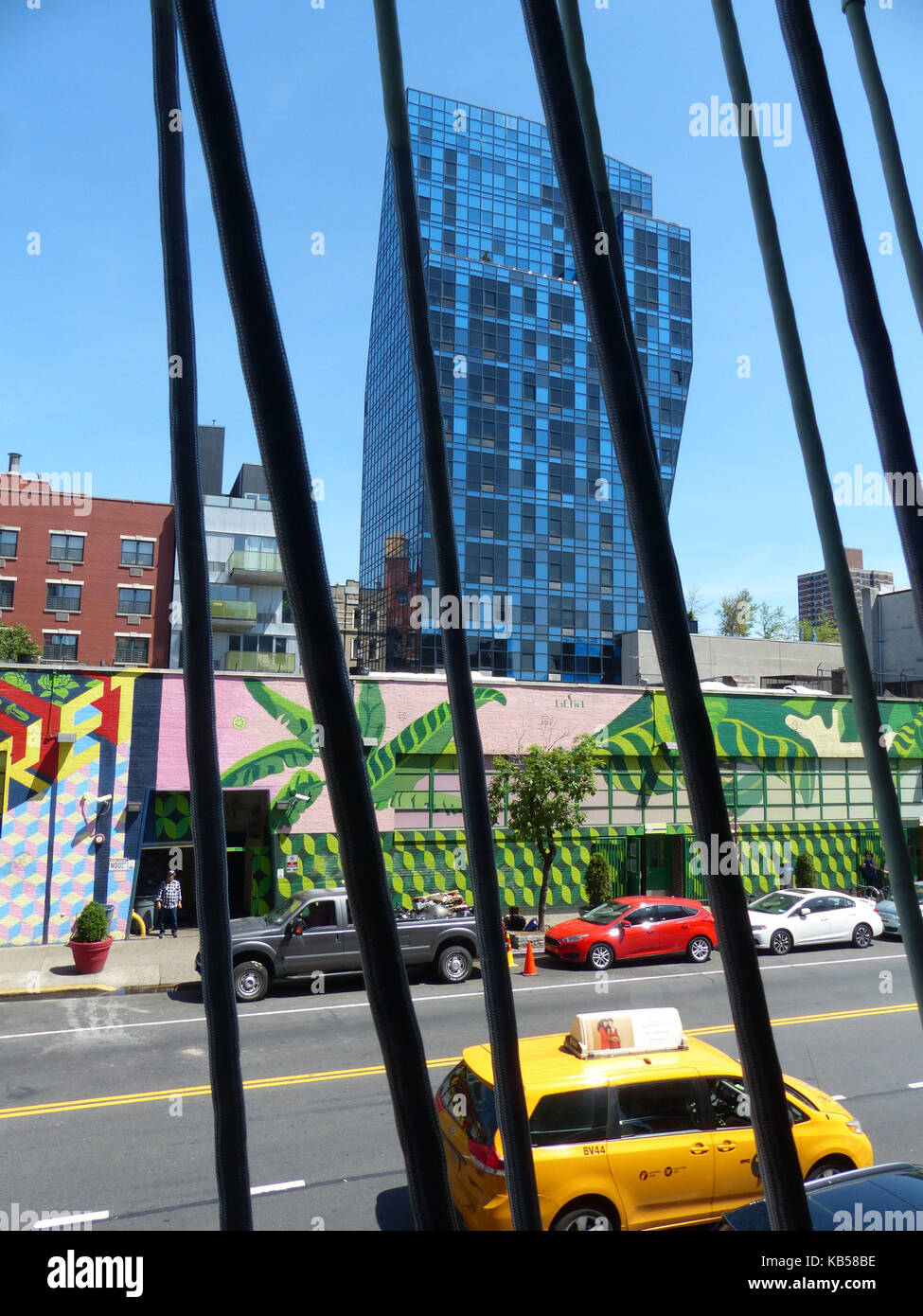 Delancey Street condominio blu, aka blue tower progettato dall architetto Bernard Tschumi, fotografata attraverso il garage per il parcheggio sulla strada di essex con yellow cab passando da Foto Stock