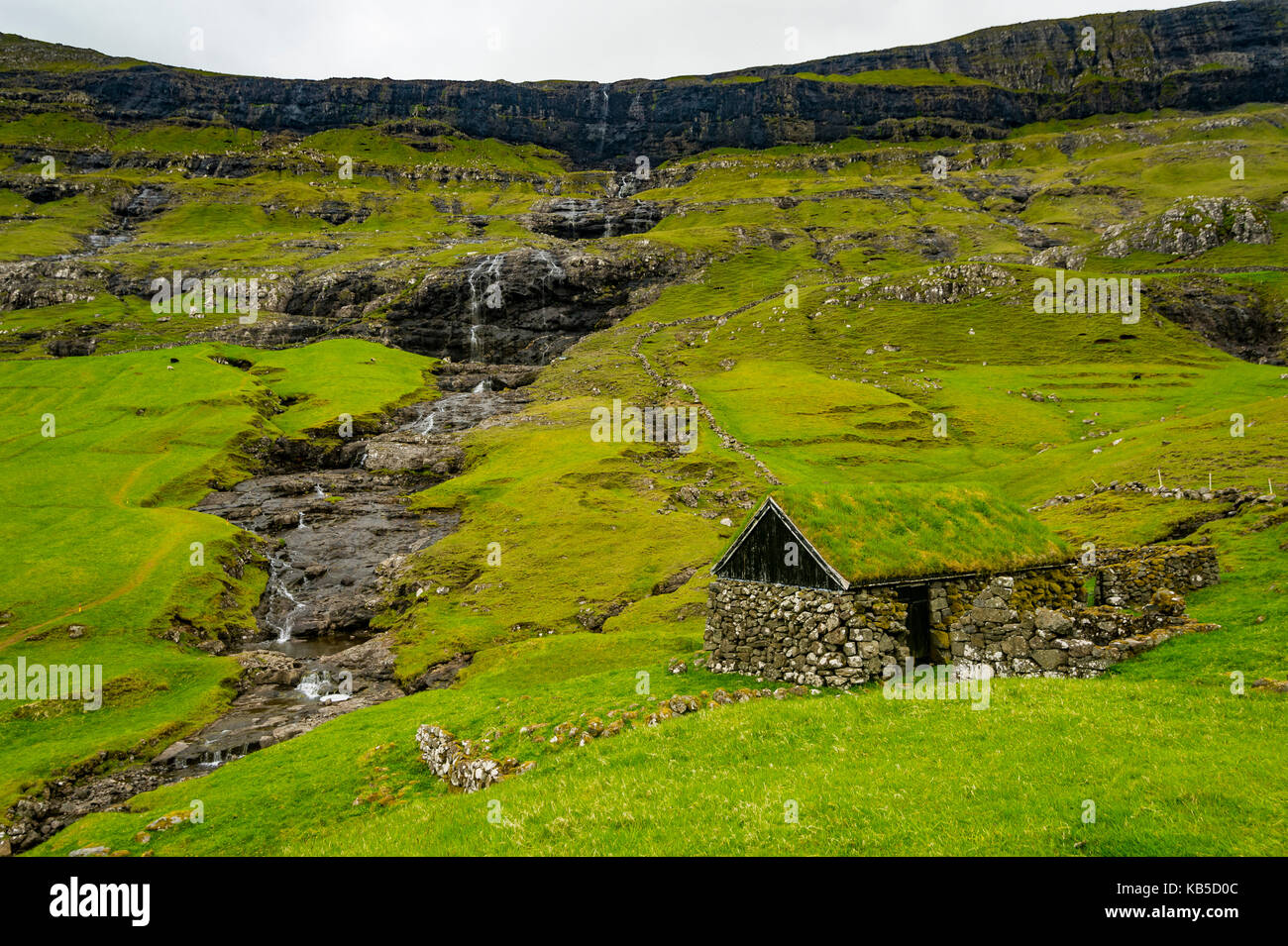 Grasstop Roof casa prima di una cascata, saksun, streymoy, isole Faerøer, Danimarca, Europa Foto Stock