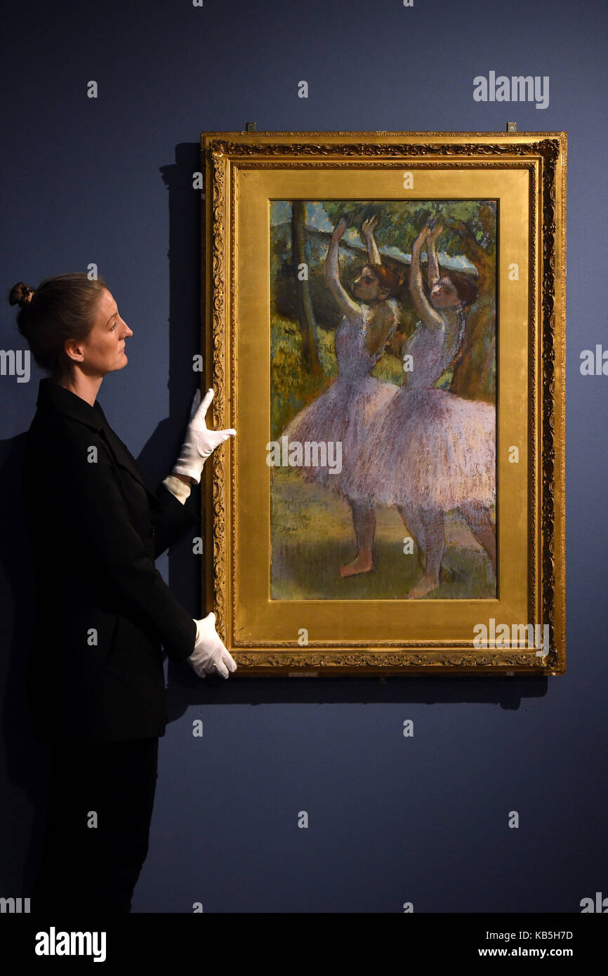 Una donna organizza ballerini in gonne di salmone di Edgar Degas che è in mostra come parte della mostra Degas: A Passion for Perfection al Fitzwilliam Museum di Cambridge. Foto Stock