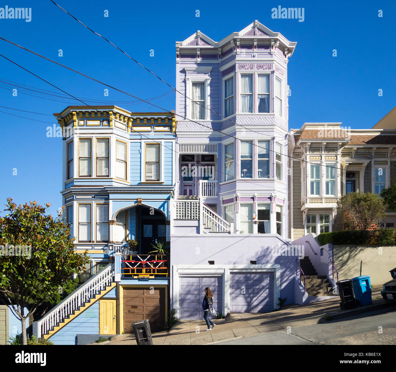 Una ragazza cammina giù Sanchez Street (nota architettura Victorian-Italianate) nel quartiere Castro / Noe Valley del Distretto di San Francisco, California. Foto Stock