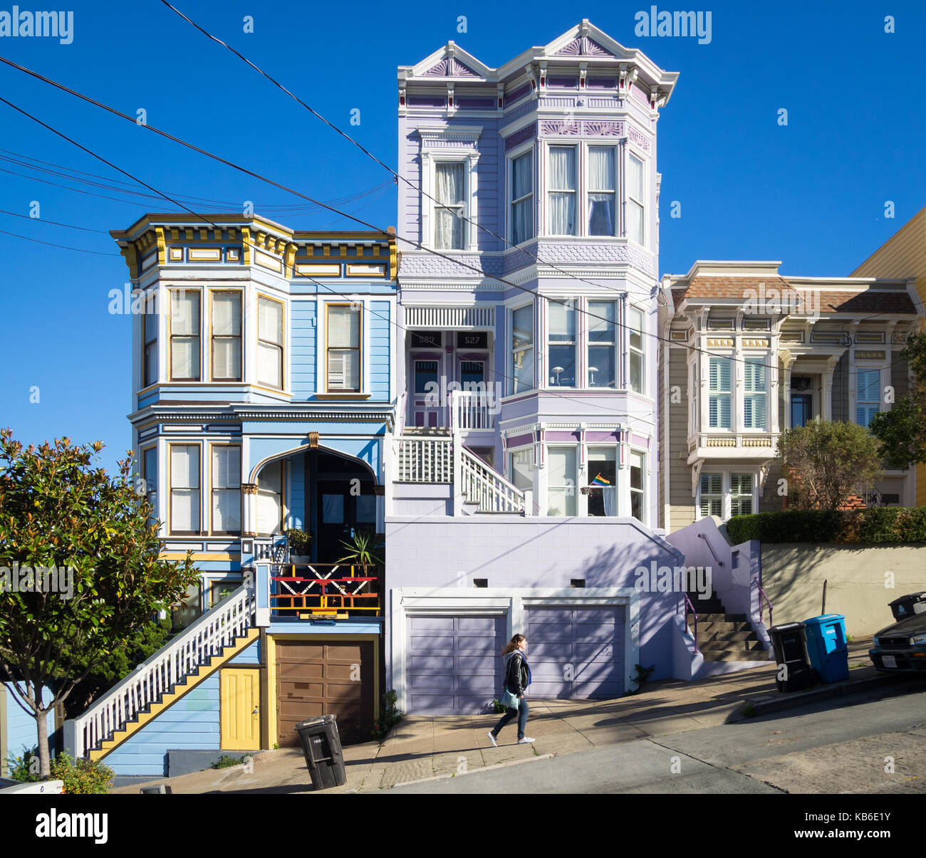 Una ragazza cammina su Sanchez Street (nota architettura Victorian-Italianate) nel quartiere Castro di San Francisco, California. Foto Stock