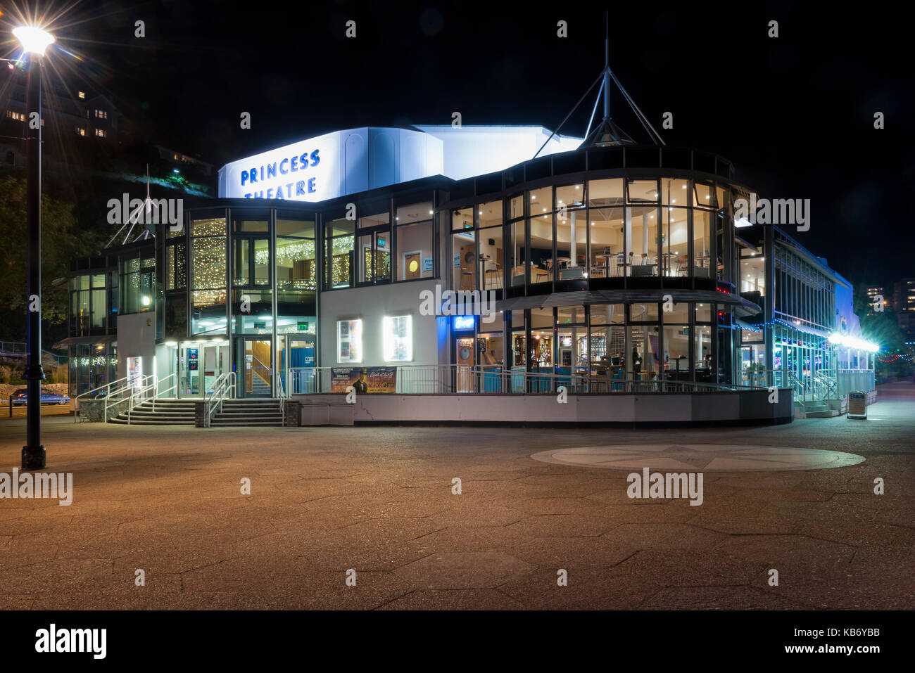 Lato, vista in alzato frontale del teatro principessa, Torquay Devon UK. illuminata di notte, la hall e il bar visibile e la passeggiata sul lungomare a lato Foto Stock