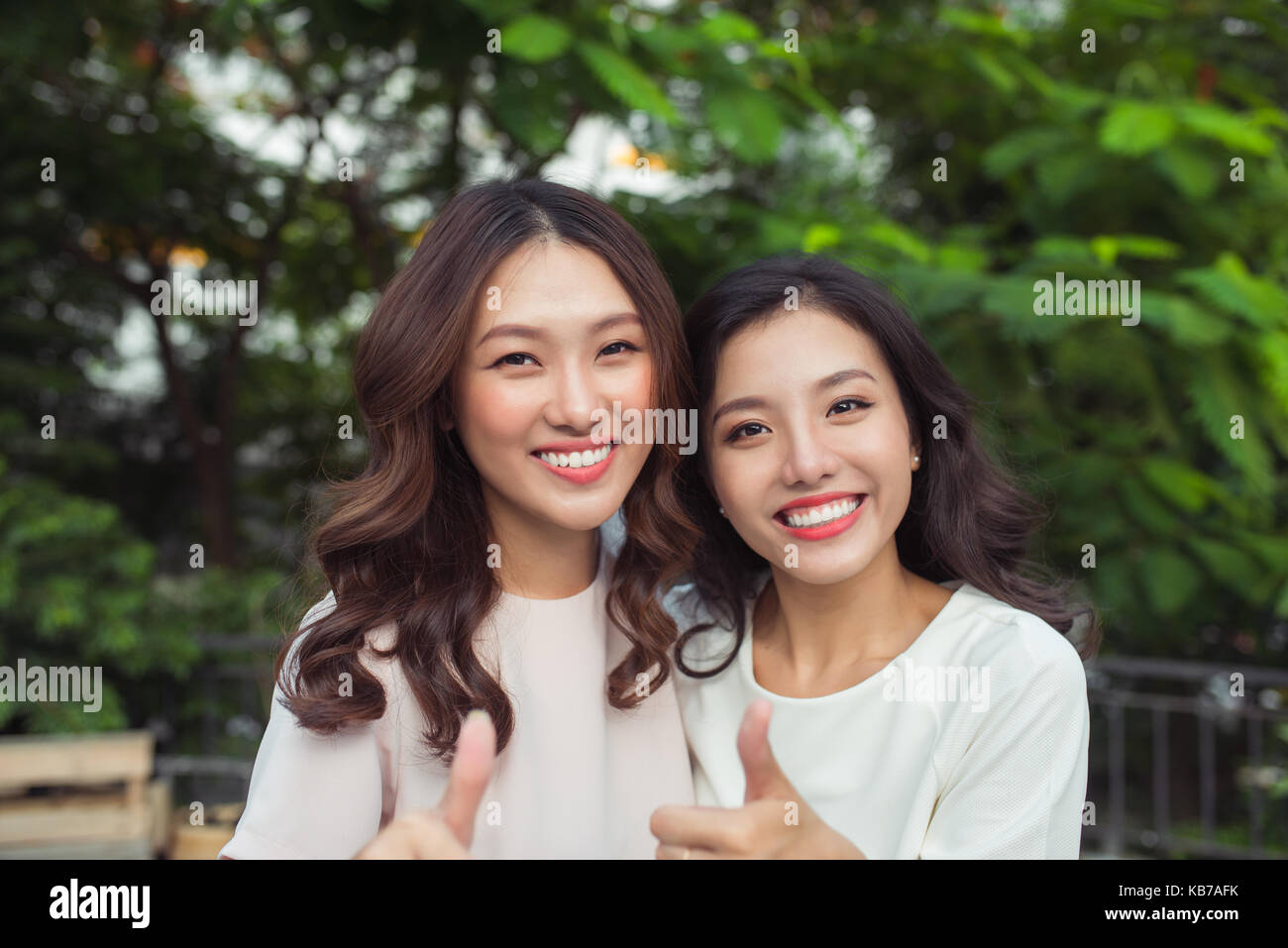 Felice di donne giovani amici ben vestito sorridere mentre in piedi insieme Foto Stock
