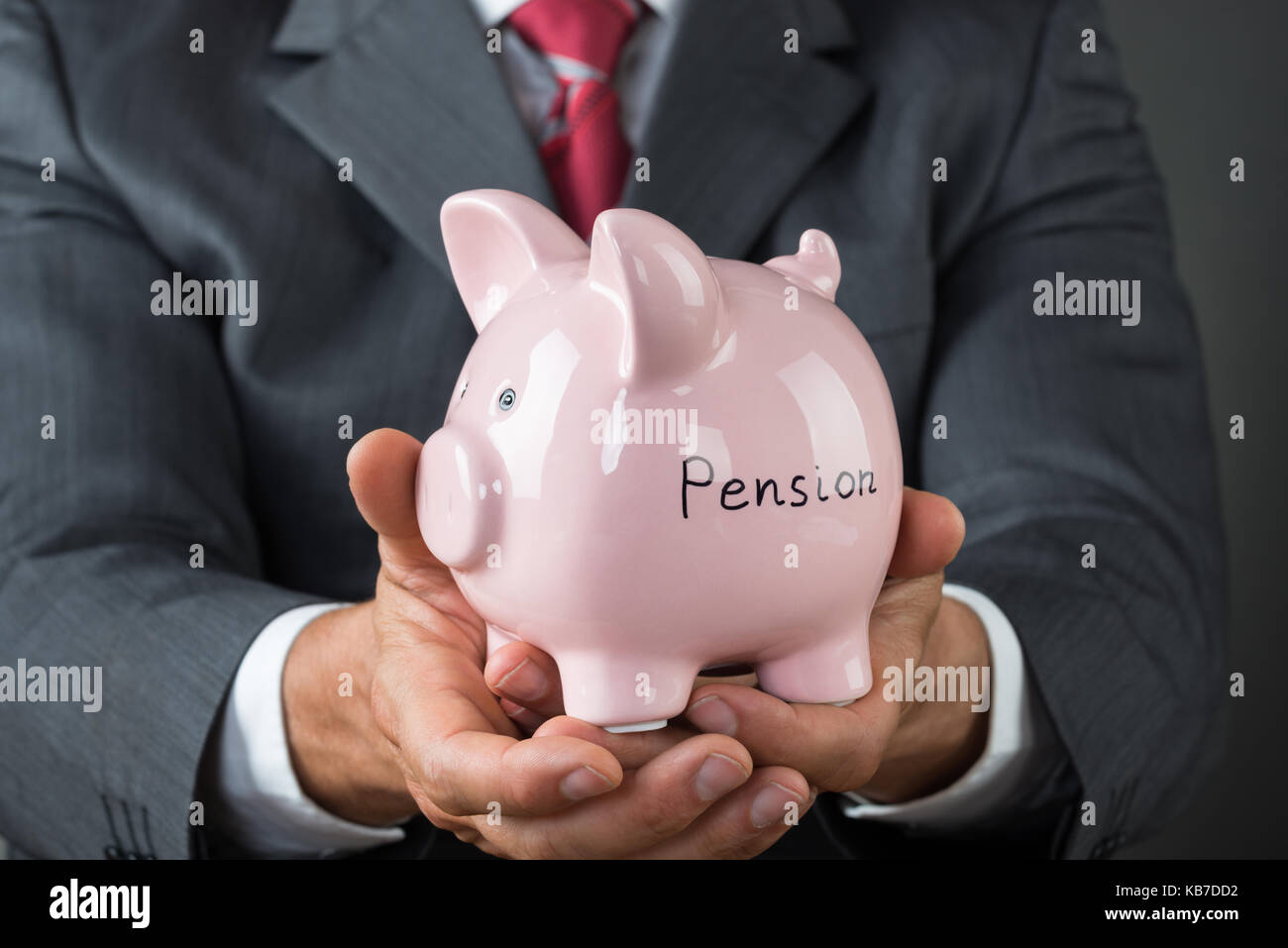 Sezione mediana di imprenditore tenendo salvadanaio con pensione scritto su di esso Foto Stock