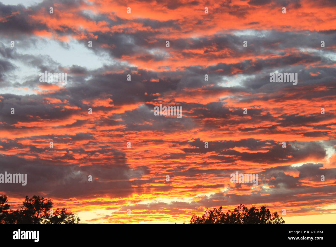 Il sole che tramonta creando le nuvole colorate Foto Stock