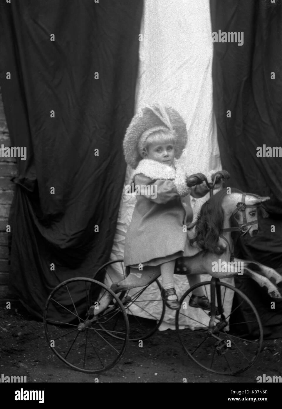 AJAXNETPHOTO. 1890 - 1914 (circa). Posizione sconosciuta. - Ben vestito bambino TODDLER indossando cappotto e cofano SAT a cavallo di un cavallo in stile vittoriano di triciclo in posa per la fotocamera. Il trike ha GOMME PIENE. Fotografo:sconosciuto © IMMAGINE DIGITALE COPYRIGHT VINTAGE AJAX Picture Library Fonte: AJAX FOTO VINTAGE COLLEZIONE REF:AVL 172109 1674 Foto Stock