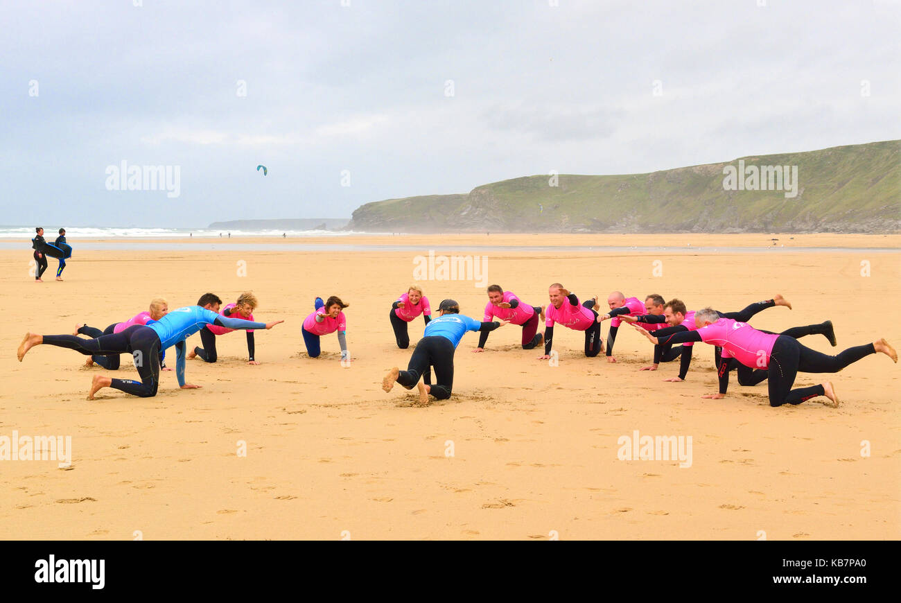 Istruttori di Surf dando lezioni di surf per i partecipanti sulla spiaggia, a Watergate Bay, Newquay Cornwall, England, Regno Unito Foto Stock