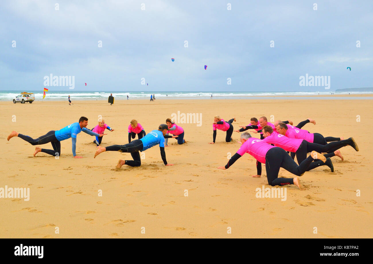 Istruttori di Surf dando lezioni di surf per i partecipanti sulla spiaggia, a Watergate Bay, Newquay Cornwall, England, Regno Unito Foto Stock