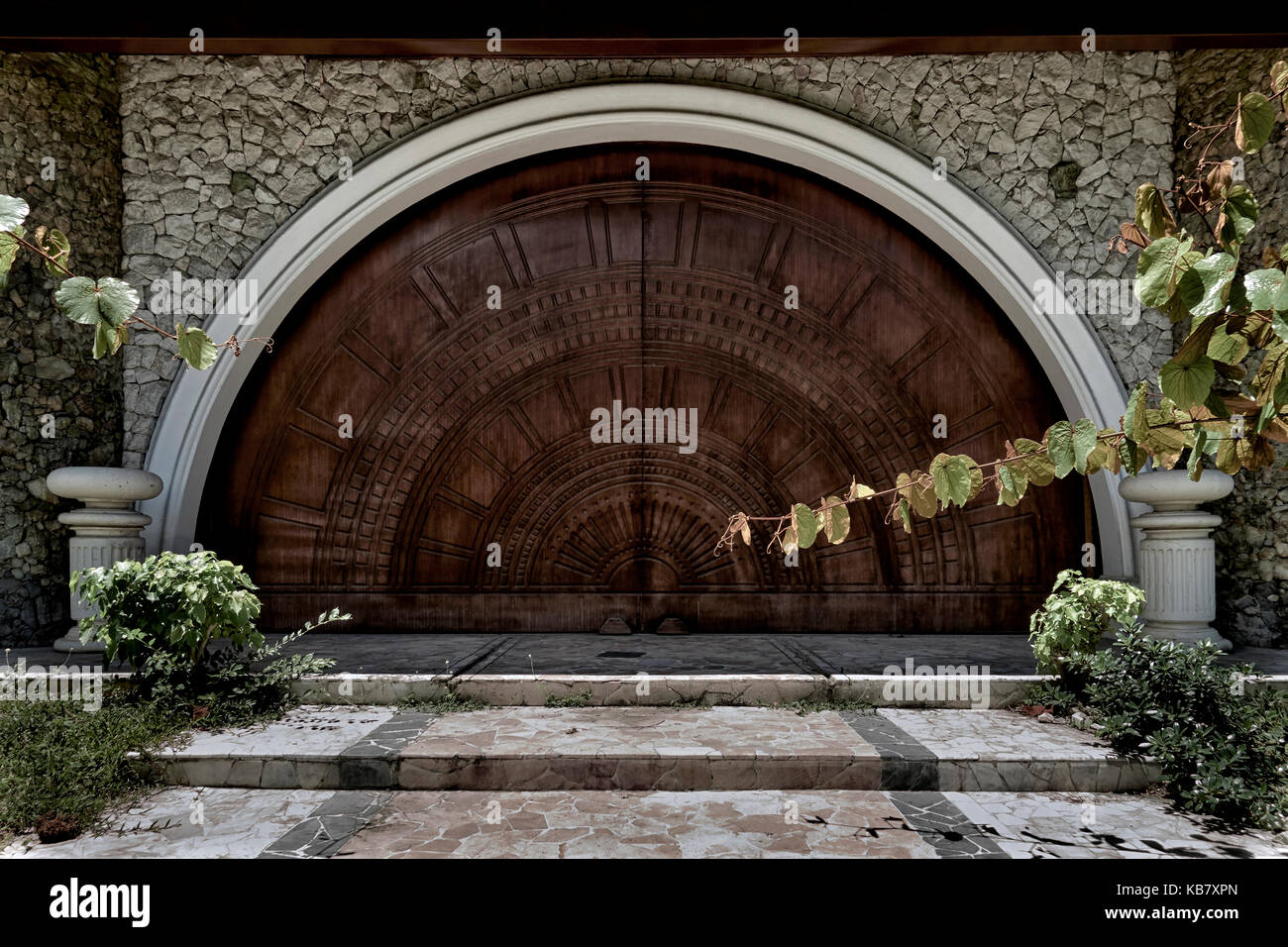 Porta ad arco. Porta ad arco in legno intagliato e fortemente goffrato. Porta di quercia. Porta in legno. Foto Stock