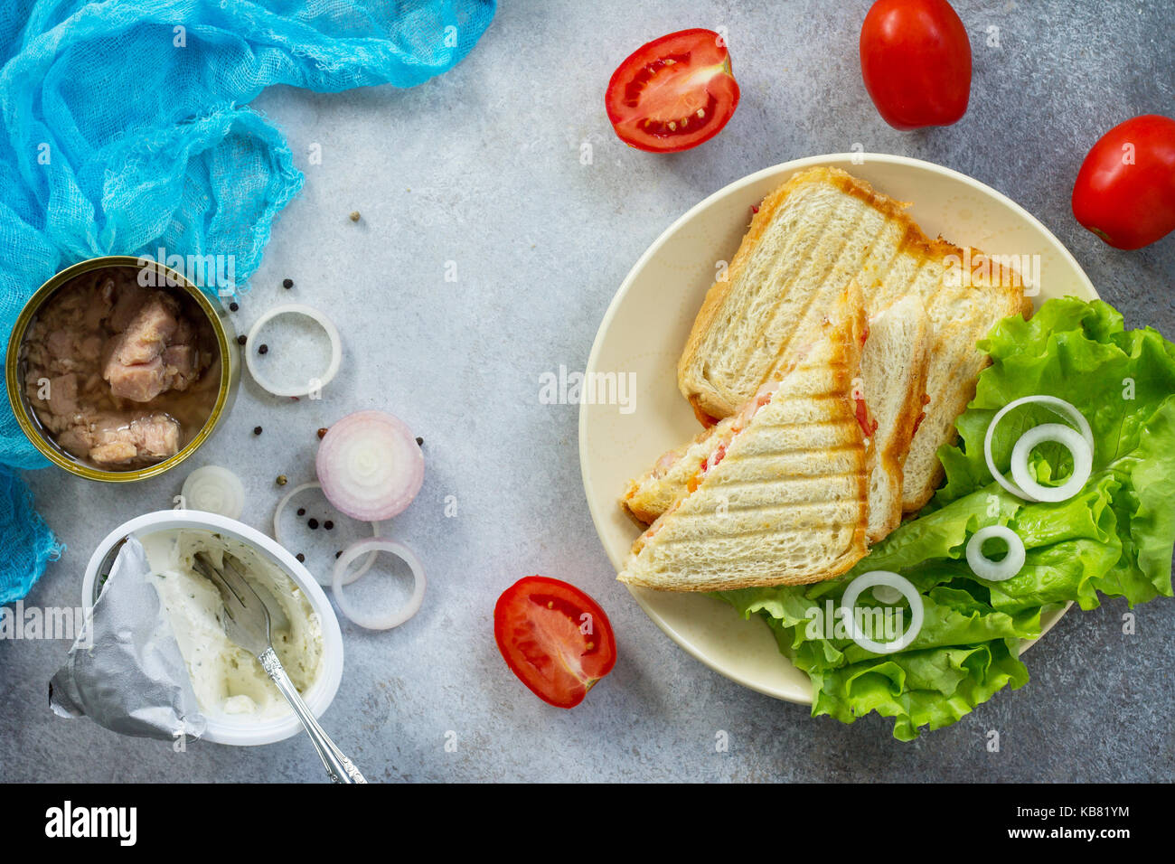 Doppia con sandwich di tonno in scatola e il formaggio feta servite con foglie di lattuga su un tagliere di legno. Foto Stock