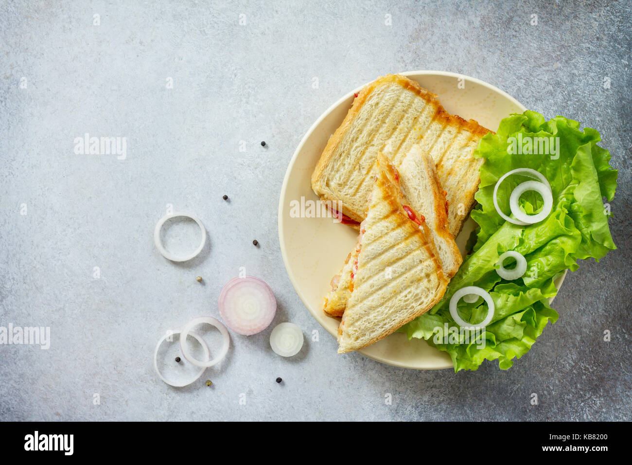 Doppia con sandwich di tonno in scatola e il formaggio feta servite con foglie di lattuga su un tagliere di legno. Foto Stock