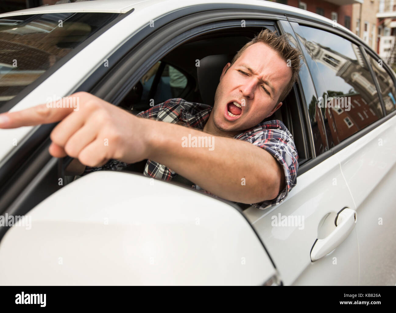 Irritato giovane uomo alla guida di un'auto. irritato conducente Foto Stock