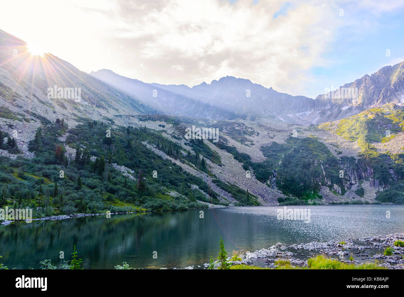 Bellissimo lago di montagna paesaggio con raggi di sole. estate vista panoramica della gamma della montagna podnebesnye zubja (kuznetsk alatau) Foto Stock