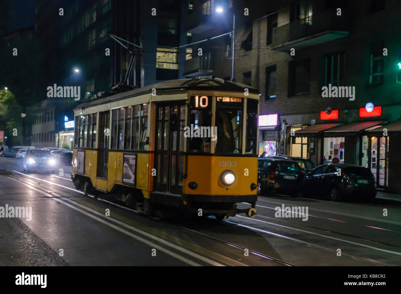 Famosi tram giallo a Milano di notte (con motion blur), costruito intorno al 1930 Foto Stock